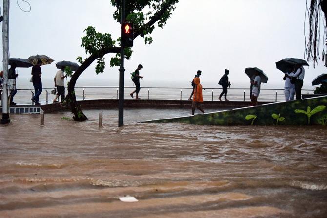 The railway authorities suspended the suburban train operations between CSMT-Vashi stations on the Harbour line, CSMT-Kurla on the mainline and also between Churchgate and Kurla due to water-logging on tracks around Masjid Bunder, Kurla, Sion, Marine Line and other stations.
In picture: Pedestrians walk on the promenade of Girgaum Chowpatty.