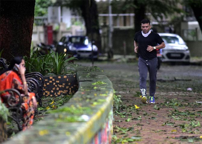 In photo: A man snapped jogging at Dadar's Shivaji Park as torrential rains accompanied with gusty winds battered Mumbai.