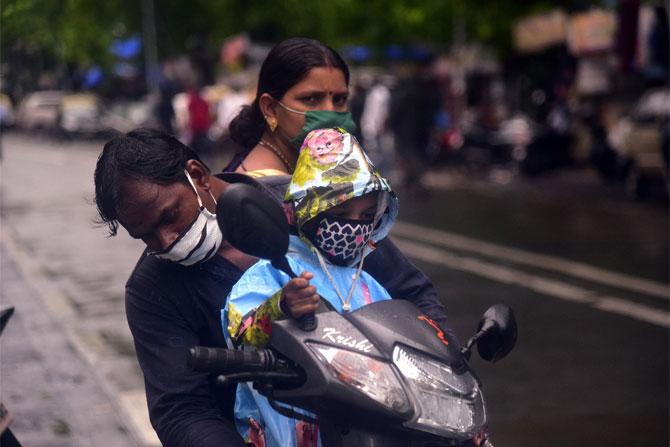 In photo: A family armed with face mask was seen getting drenched in Dadar.