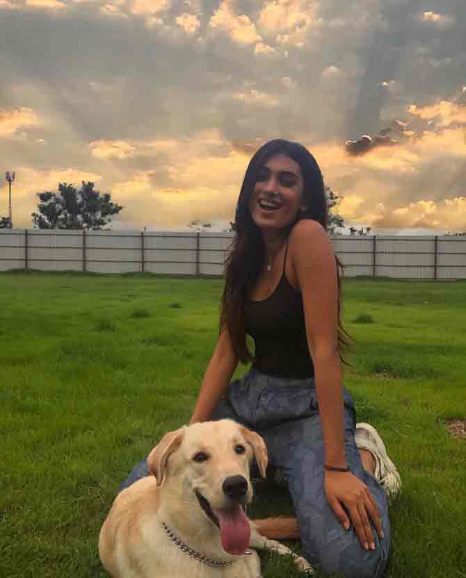 She is seen posing with her pet dog Tipu and looking simple yet elegant in a black camisole and a pair of blue cargo pants.
