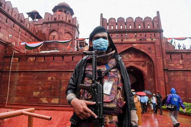 Security personnel armed with face mask stands guard during the full-dress rehearsal at Red Fort in New Delhi.