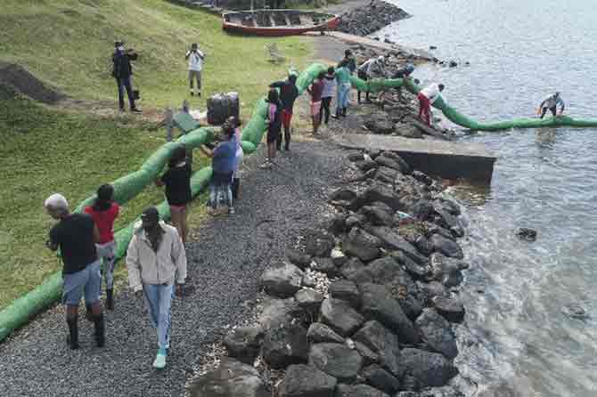 Environmental consultant and former member of the parliament Sunil Dowarakasing was quoted by AP as saying that the ship ran aground on July 25 but work to remove the oil started last week when the hull cracked and started emptying the fuel into the sea. 
In picture: Volunteers carrying the handmade oil barrier to block leaked oil.