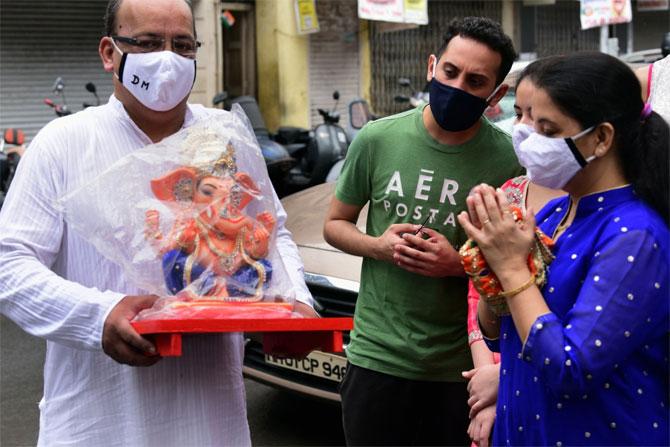 In photo: A family offers prayers to the idol of Lord Ganesh before taking it home.