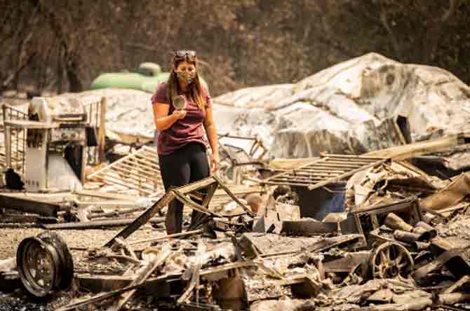 Authorities said their firefighting effort in Santa Cruz was hindered by people who refused to evacuate and some were using the chaos to loot. Hundreds of officers have been patrolling in the area and anyone not authorised to be in an evacuation zone would be arrested.
In picture: A resident looks at a cup found in the burned remains of her home during in Vacaville.