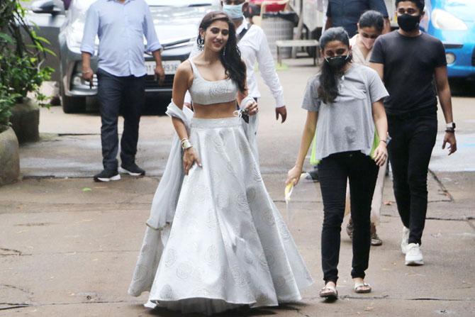 Sara Ali Khan is currently shooting at the Mehboob Studios for past few days in Bandra, Mumbai. The actress was clicked by photographers in different outfits. This time around she sported a silvered coloured contemporary style lehenga. Sara looked pretty as she posed for the photographers. All pictures/Yogen Shah