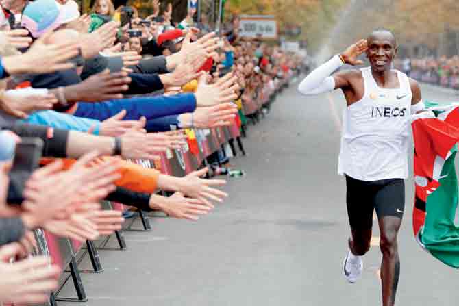 Kenya’s Eliud Kipchoge celebrates after completing a full marathon with an unofficial time of 1hr 59min 40.2sec, becoming the first ever to run a marathon in under two hours, at a specially prepared course in Prater park, Vienna. PIC/getty images