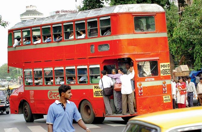 A 2004 image of commuters hanging out of a double decker bus. With the need for social distancing in view of the pandemic, the iconic buses will hit the road again. Pic/Getty Images