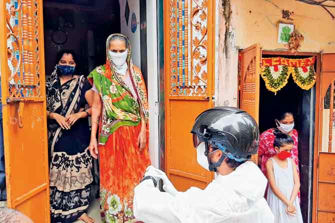 Health workers check the temperature of Gorai residents with a digital helmet. PIC/SATEJ SHINDE