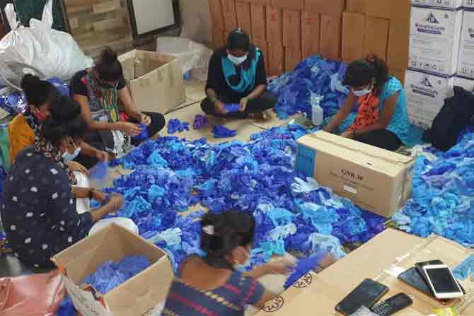 Women packing gloves at factory unit