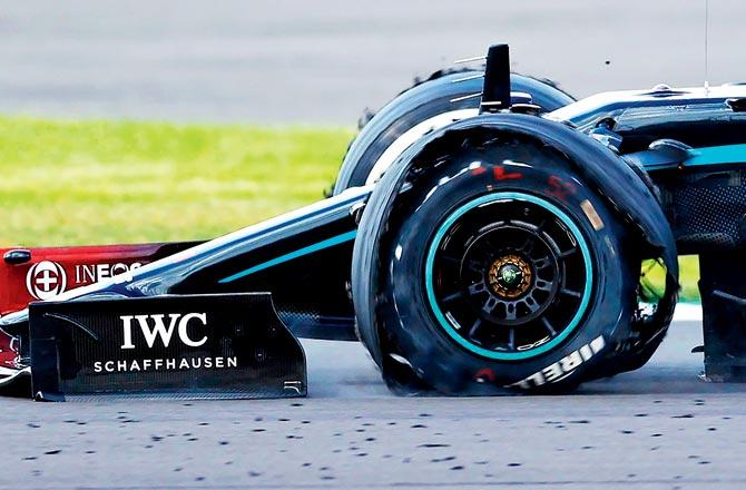 Lewis Hamilton drives his punctured Mercedes car during the last lap of the British GP on the Silverstone circuit yesterday. The defending champion crossed the finish line on just three tyres