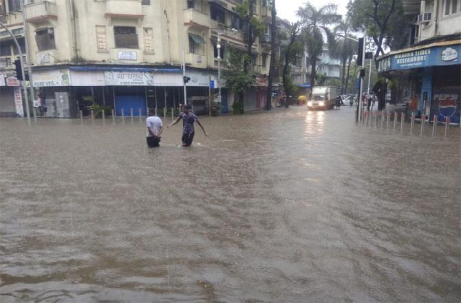 People wade through flooded streets at Hindmata near Dadar. Pic: Suresh KK