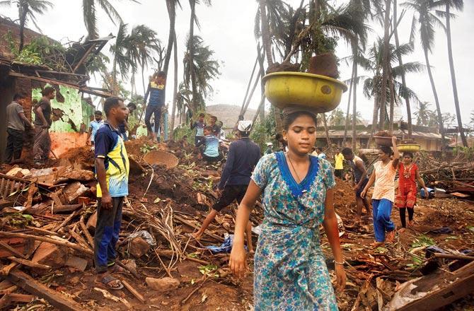 Villagers clear debris of a house destroyed in the June 3 cyclone at Ade village on Friday. Pic/Atul Kamble