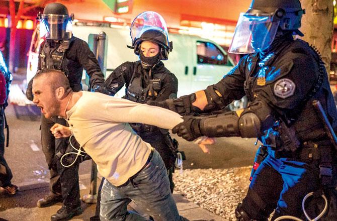 Officers hold back a man who was with the victim on Saturday night. Pics/AFP