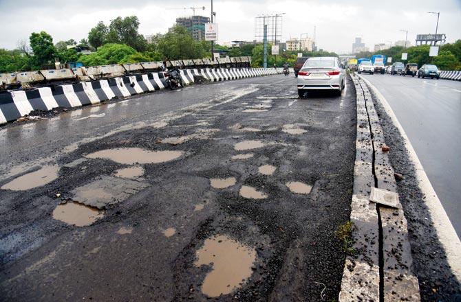 The potholes-ridden stretch shows down traffic and poses a huge threat to motorists. Pics/Sameer Markande