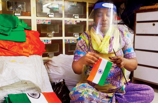 A woman makes a tricolour flag in preparation for Independence Day at Mahalaxmi. Pic/Ashish Raje