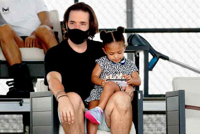 Alexis Ohanian watches wife Serena Williams in action while daughter Olympia seems to  busy with a toy in Kentucky  on Tuesday. Pic/AFP