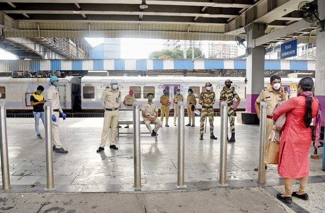 A Mumbai police personnel checks an essential services employee