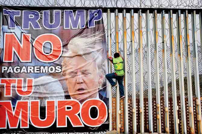 A member of Border Angels hangs a banner reading “Trump we will not pay for your wall” during a demonstration against him at the  US-Mexico border in Playas de Tijuana, Baja California state, Mexico, on February 2, 2020. Newly built walls, fences, and gates had risen over 60 international boundaries, blockading the movement of over four billion people around the world, says Sonia Shah. PIC/AFP