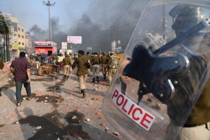 February 22: Northeast Delhi riots- Riot police walk along a road scattered with stones following clashes between supporters and opponents of a new citizenship law, at Bhajanpura area of New Delhi, ahead of US President arrival in the capital.