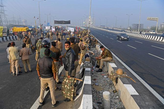 Security personnel stand guard on a road during a nationwide general strike called by farmers to protest against the government's recent farm laws at the Delhi-Uttar Pradesh state border in Ghazipur on December 8, 2020. Photo: AFP