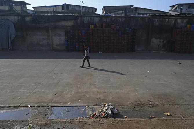 A worker walks through an empty parking area of the Agricultural Produce Market Committee (APMC) yard , in Navi Mumbai on December 8, 2020, during a nationwide general strike called by farmers to protest against the farm laws recently introduced by the government. Photo: AFP