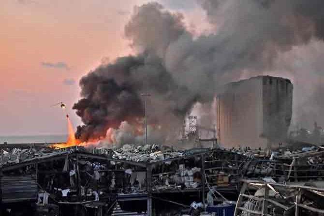 August 4: Beirut blast- A helicopter puts out a fire at the scene of an explosion at the port of Lebanon's capital Beirut. Two explosions caused by unsafely stored ammonium nitrate kill over 220 people, injure thousands, and severely damage the port in Beirut, Lebanon. Damage is estimated at $10–15 billion, and an estimated 300,000 people were left homeless. 