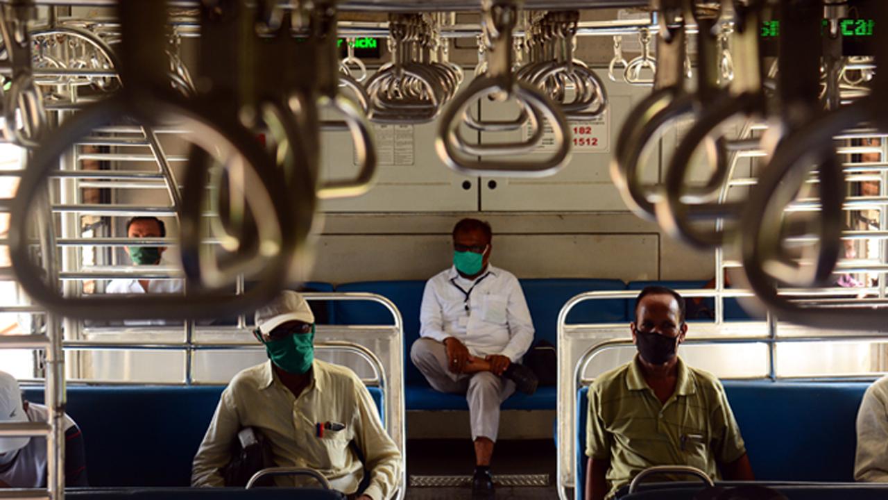 
Essential workers armed with face masks maintain social distancing norms while travelling on Mumbai local train amid the COVID-19 crisis in the city.
