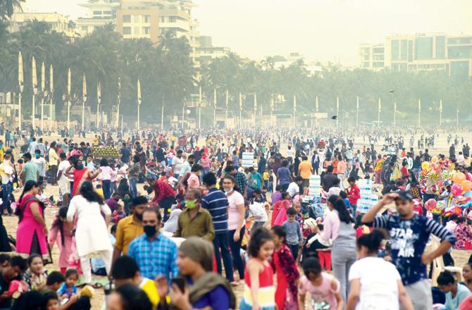 Social distancing goes for a toss as a huge crowd gathers at Juhu Chowpatty on Sunday, even as the COVID-19 pandemic rages on. Pic/Atul Kamble