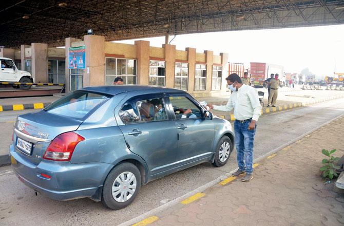 Health workers take body temperature readings of passengers of a car at Dapchari checkpost on December 18.