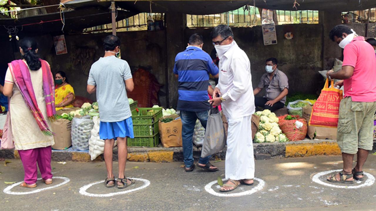 A bunch of early morning shoppers maintain social distancing as they queue up to buy vegetables in a market at Bhoiwada.
Photo: Suresh Karkera