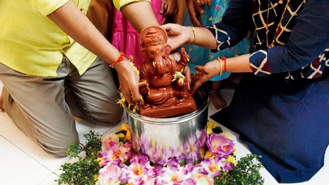 A family from Mulund East immerses their Ganesha idol made of mud in a steel container during Ganesh Visarjan in Mumbai.
Photo: Sameer Markande