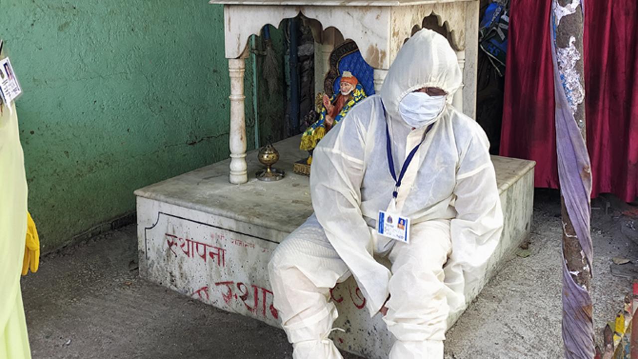 A volunteer wearing personal protective equipment (PPE) suit gets ready to conduct door-to-door thermal screening of the residents of Mumbai.
Photo: Pradeep Dhivar