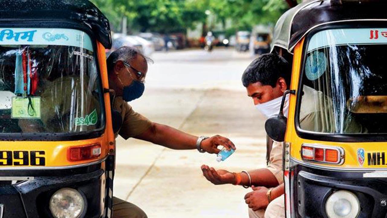 Two auto drivers armed with face masks share sanitiser in Goregaon East.
Photo: Anurag Ahire