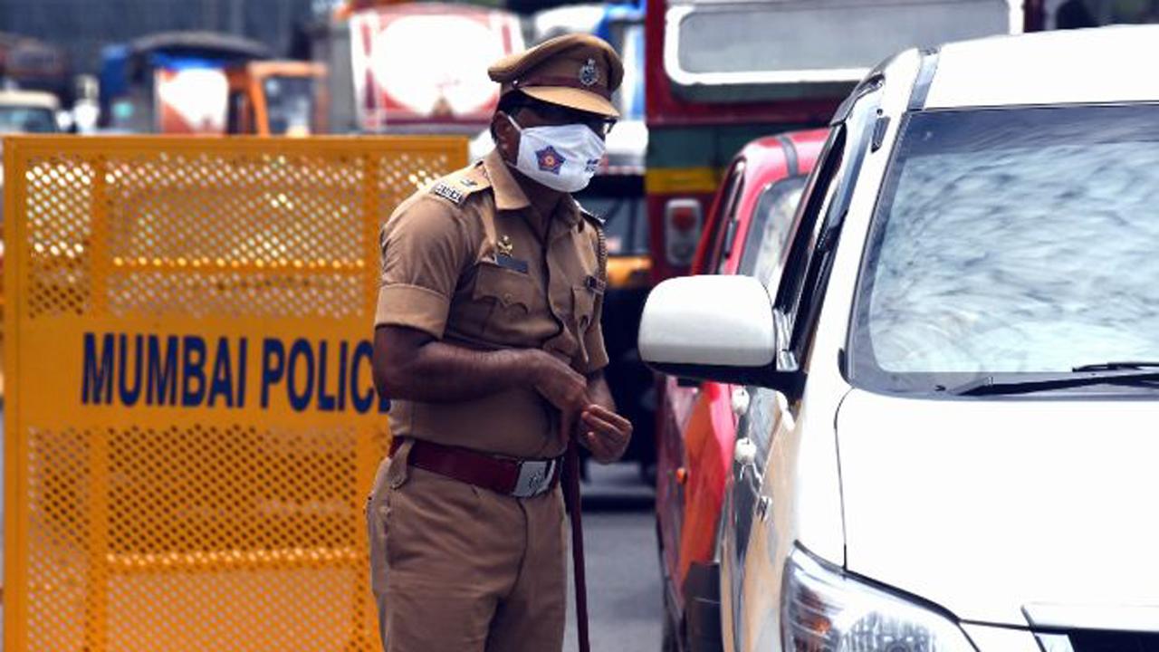A police officer checks a vehicle during a police blockade at Western Express Highway in Borivli amid total lockdown in the city.
Photo: Nimesh Dave