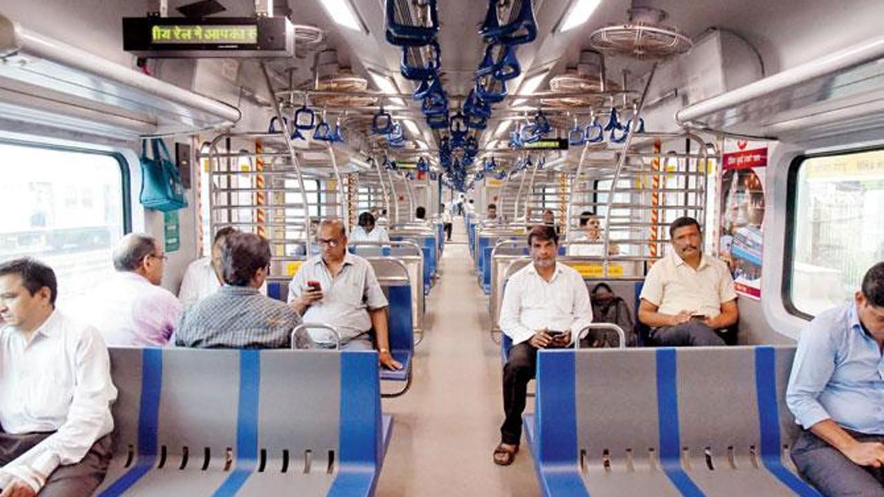 The Central Railway will run four services between CSMT and Kurla, two on the CSMT-Kalyan route and four between CSMT and Dombivli (Thane) from Monday to Saturday, with the trains halting at all stations.
In picture: Commuters maintain social distancing as they enjoy a rise on Central Railway's new AC local service. Photo: Nimesh Dave