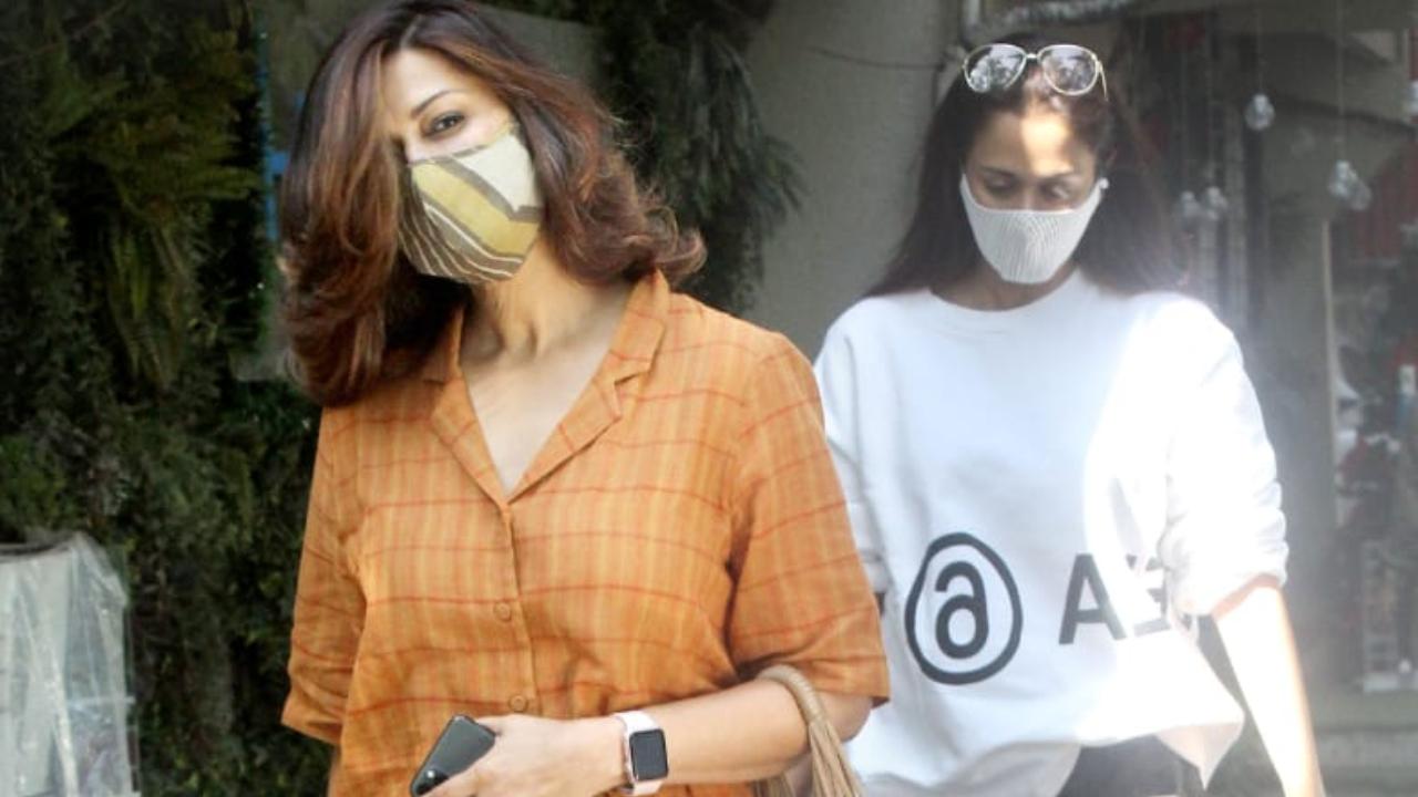 Sonali Bendre was snapped with her BFF Gayatri Oberoi at a popular dubbing studio in Juhu, Mumbai. While Gayatri opted for a white t-shirt and grey trousers, Sonali looked radiant in her orange jumpsuit. She carried a brown handbag to complete her look. (All pictures: Yogen Shah).