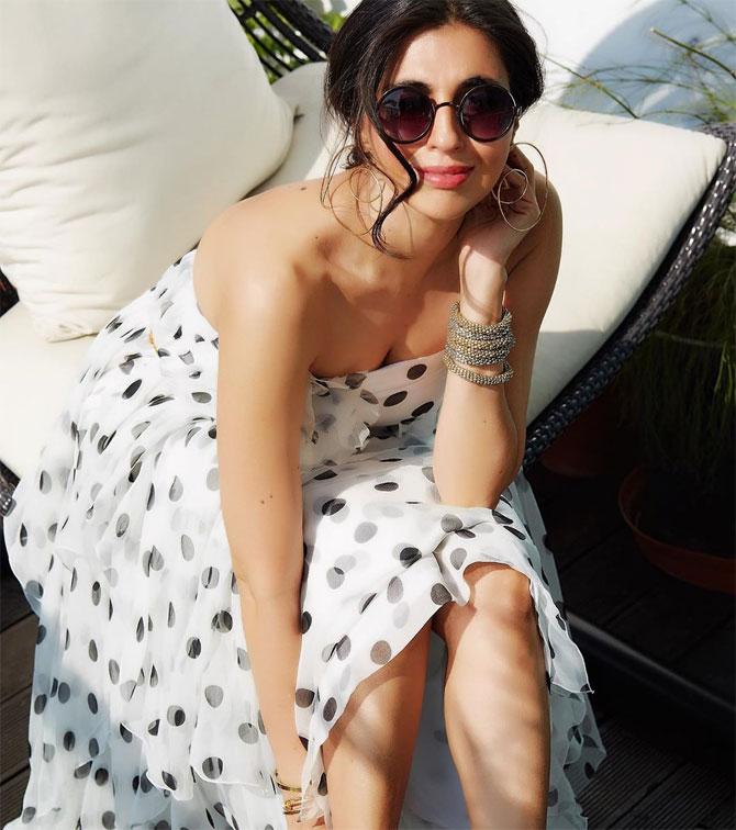 She gives the sun a run for its money in this white and black polka-dotted cocktail dress with the sunglasses stealing the show.