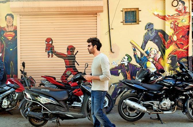 Actor Kartik Aryan walks past a graffiti decorated wall outside a studio in Andheri on Wednesday. Pic/Satej Shinde