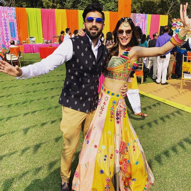 For her friend's wedding, Nusrat Jahan opted for a multi-coloured sleeveless lehenga which she paired with chunky jewellery. In order to compliment her outfit, Nusrat left her beautiful long tresses parted on both sides with a maang tikka. While Nusrat's husband Nikhil Jain complimented his wife by opting for a casual look paired with a printed Nehru jacket in hues of black.