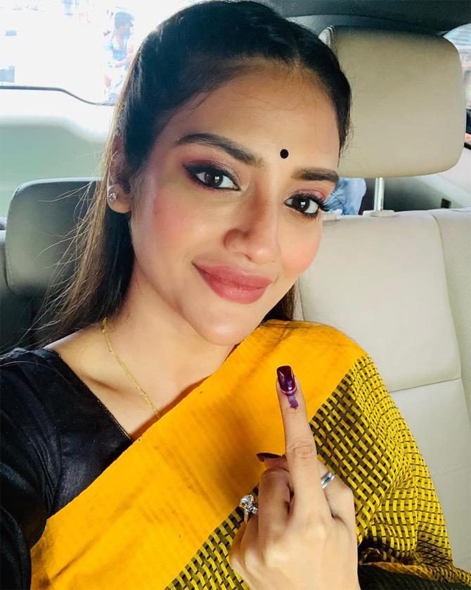 In picture: Donning a beautiful yellow saree paired with a black blouse, Nusrat Jahan shows off her inked finger as she urges people to cast their votes during the 2019 Lok Sabha elections.