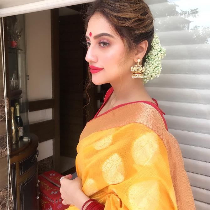 Nusrat Jahan's Instagram is filled with pictures from western wear to ethnic ensembles all in different shades of yellow. Sharing a leaf out of festival celebrations, Nusrat can be seen donning a beautiful yellow saree with golden borders which she complemented with a red blouse. Nusrat completed her festive look with red lipstick and dewy makeup. Nusrat captions this one: Subho Maha Sashthi...!