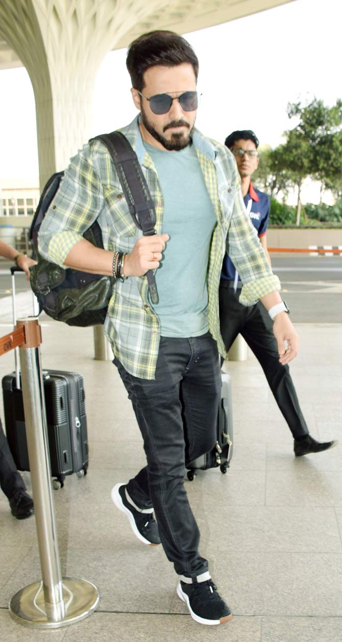 Emraan Hashmi along with wife Praveen Shahani was spotted at the Mumbai airport. Emraan sported a casual look in a striped shirt, basic tee and denim. All pictures/Yogen Shah