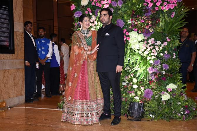 For the grand event, Shloka Mehta donned a multi-coloured lehenga choli by designer Sabyasachi Mukherjee and paired her regal outfit with a stunning emerald choker neckpiece, matching kundan earrings and a maang tikka. Shloka completed her elegant look by tying her hair in a neat sleek low bun. On the other hand, Akash Ambani complemented his wife by opting for a black bandhgala and sported a stubble look.