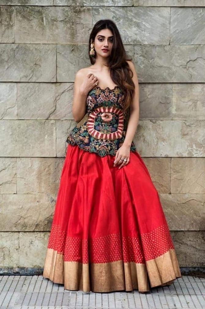 In photo: Nusrat Jahan, who is seen sporting a beautiful top looks adorable as she pairs it with a stunning red skirt with golden borders