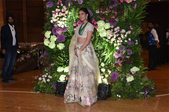 Radhika Merchant, who also graced the wedding reception opted for a cream coloured floral backless lehenga which she paired with a green emerald neckpiece and matching earrings. Radhika completed her look with subtle makeup and minimal accessories. She tied her beautiful tresses in a ponytail
