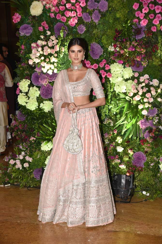 Tara Sutaria, who is said to be dating Aadar Jain, looked extremely elegant in a peach and silver outfit. She completed her look with a silver choker and a white potli bag during the reception.