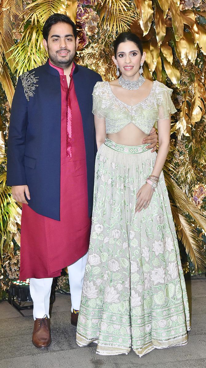 Dressed in traditional attires, both Akash and Shloka were all smiles for the cameras as they arrived for Armaan Jain's wedding bash. For the grand event, Shloka Mehta looked extremely elegant in a cream and green lehenga outfit. She completed her look with a silver choker neckpiece and diamond earrings. With subtle makeup and minimal accessories, Shloka tied her hair in a neat bun.