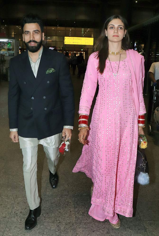 The newlywed couple Simran Kaur Mundi and Gurickk Maan, son of popular singer Gurdass Mann, were clicked at Mumbai Airport. Simran looked gorgeous as the new bride as she wore a pink suit, paired with Punjabi chooda, traditional jewellery. Gurickk opted for a classy suit. (All pictures: Yogen Shah)