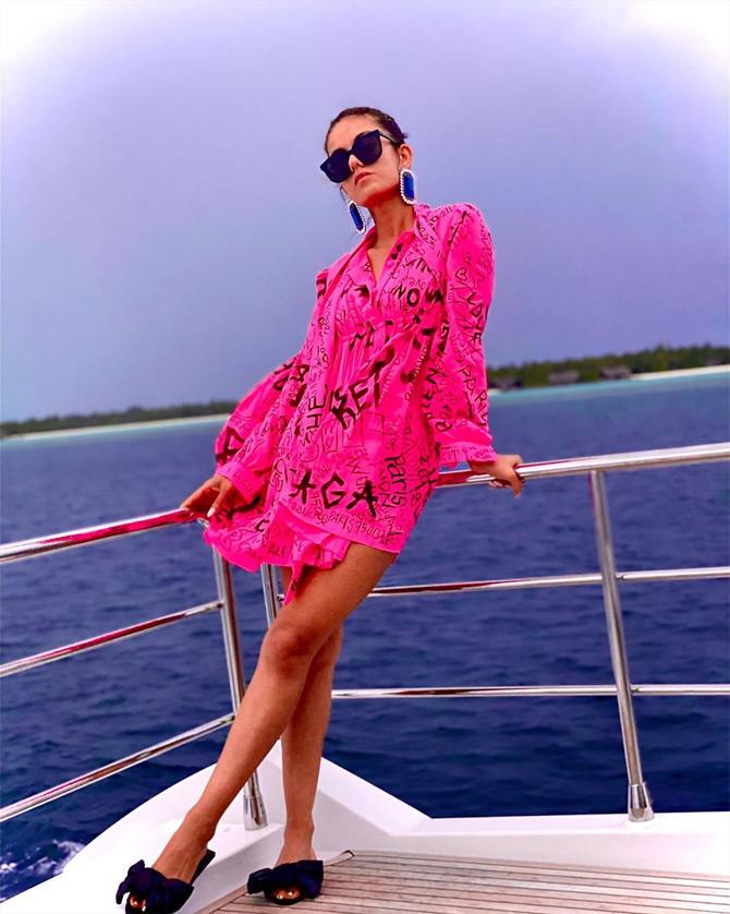 Natasha Poonawalla shared this picture from one of her exotic cruise trips. In the picture, Natasha who can be seen raising the temperatures in a pink dress enjoys her cruise journey as she poses for a picture amidst the backdrop of a blue waters
