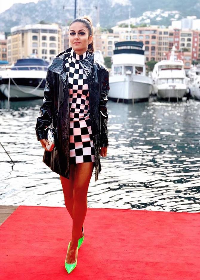 In photo: Donning a black and white checkered dress and completing her look with a black leather jacket, Natasha Poonawalla makes a grand entry at the Monaco Grand Prix amidst the sea filled with cruise ships

